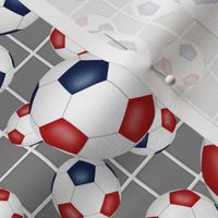 Red white and blue soccer balls w goal net detail on gray