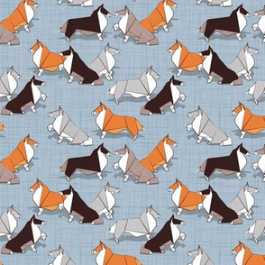 Tiny scale // Origami Collie friends // pastel blue linen texture background white orange & brown paper and cardboard dogs