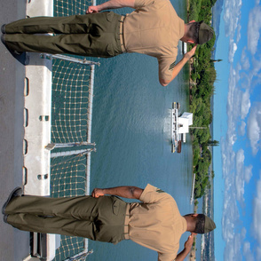 70-13 Two Marines render salutes to the the USS Arizona Memorial upon entering Pearl Harbor.