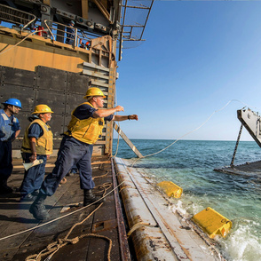 75-4 Boatswain’s Mate tosses a line to Landing Craft Unit 1648 for a stern gate marriage with the amphibious dock landing ship USS Harpers Ferry