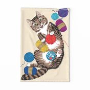 Cat playing with yarn tea towel - on light background