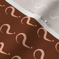 Question Marks of Pale Coral on Chocolate Fudge
