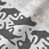 Tiny Trotting black Labrador Retrievers and paw prints - white