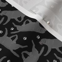 Tiny Trotting black Labrador Retrievers and paw prints - black