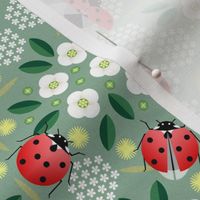 ladybugs and flowers on green