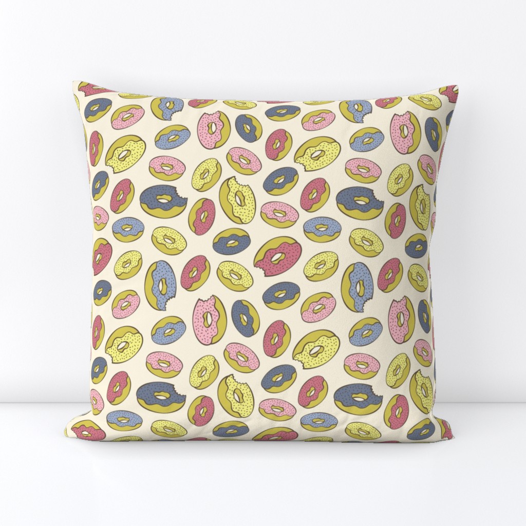 Pink, blue, yellow doughnuts (donuts), creamy yellow background