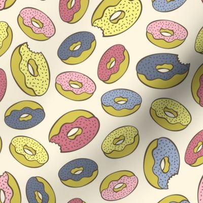 Pink, blue, yellow doughnuts (donuts), creamy yellow background