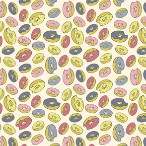 Pink, blue, yellow doughnuts (donuts), creamy yellow background