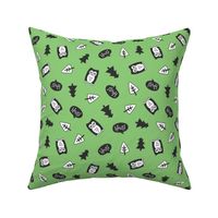 Cute owls and trees tossed on a bright green background