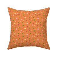 Pink, red, green, and yellow dots on an orange background