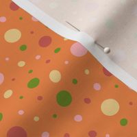 Pink, red, green, and yellow dots on an orange background