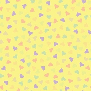 Small scale pastel hearts and silhouettes abstract pattern on a yellow background