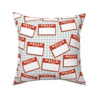 Scattered German 'hello my name is' nametags - red on grey gingham