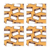 Scattered Hebrew 'hello my name is' nametags - brown on yellow/orange gingham