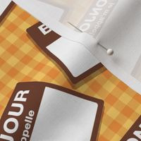 Scattered French 'hello my name is' nametags - brown on yellow/orange gingham
