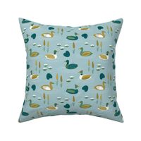 Little ducks swimming in a pond with lilies and riet spring animals minty blue green
