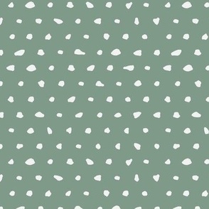 White hand drawn dots on green background