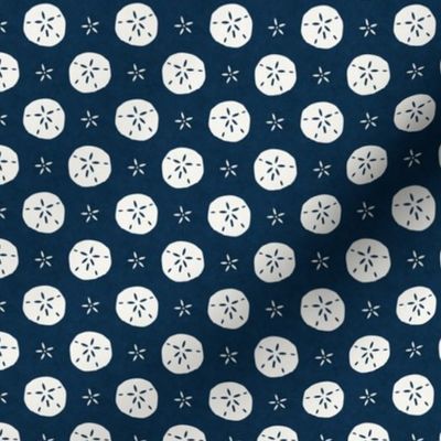 Small Scale Sand Dollars on Navy Blue Ocean Water Background 