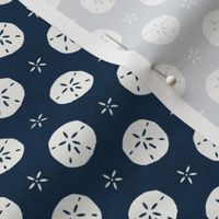 Small Scale Sand Dollars on Navy Blue Ocean Water Background 
