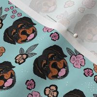 Blossom Rottweiler puppies with flowers and leaves freehand drawn dog illustration in pink gray caramel on blue