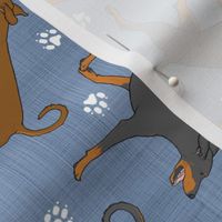 Trotting natural Doberman Pinschers and paw prints - faux denim