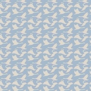 Tiny swans silhouettes on blue gray