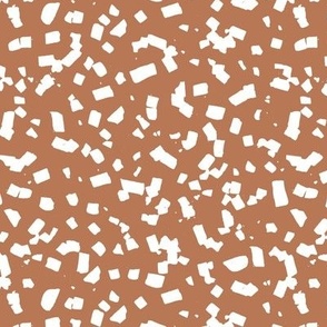 Paper confetti chocolate flakes spots and abstract dots Scandinavian style boho minimalist nursery painted design white on terracotta warm burnt orange