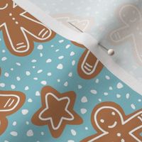 Little Christmas cookies and gingerbread men in ginger cinnamon on teal blue