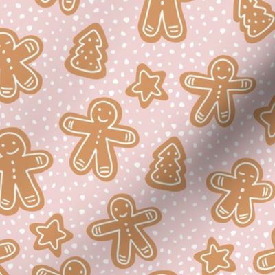 Little Christmas cookies and gingerbread men in ginger cinnamon on coral pink blush