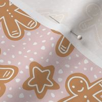 Little Christmas cookies and gingerbread men in ginger cinnamon on coral pink blush