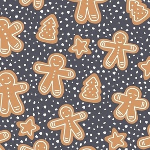 Little Christmas cookies and gingerbread men in ginger cinnamon on charcoal grey 