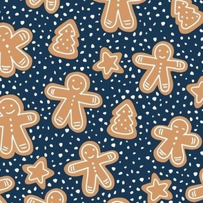 Little Christmas cookies and gingerbread men in ginger cinnamon on navy blue
