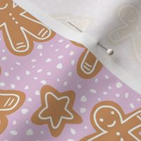 Little Christmas cookies and gingerbread men in ginger cinnamon on pink