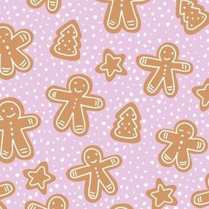Little Christmas cookies and gingerbread men in ginger cinnamon on pink