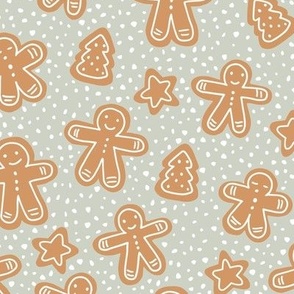 Little Christmas cookies and gingerbread men in ginger cinnamon on sage green