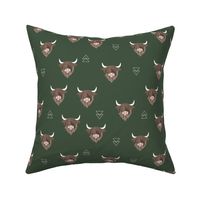 Sweet highlands with white horns and fuzzy hair highland cows rust brown on deep forest green