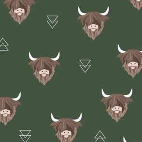 Sweet highlands with white horns and fuzzy hair highland cows rust brown on deep forest green