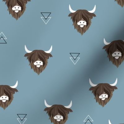 Sweet highlands with white horns and fuzzy hair highland cows rust brown on moody blue 