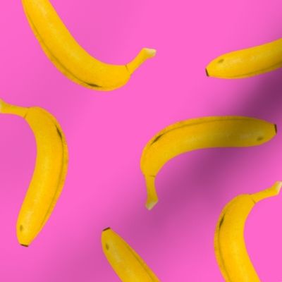 Yellow bananas tossed hot pink background 