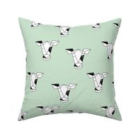 Geometric black and white cow abstract farm animals design for kids on fresh spring mint green 