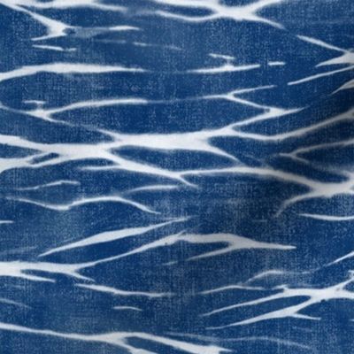 Shibori Linen in Bright Indigo (large scale) | Deep blue arashi shibori pattern, pole wrapping, rustic linen texture, boho tie dye fabric in blue and white.