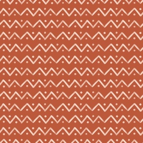 Hand drawn mudcloth design with zigzag lines and dots in rust, medium