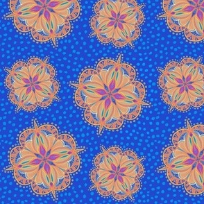 Peach and pink gloaming handdrawn mandala on blue background with spots