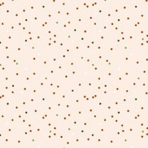 Christmas confetti, small colorful random dots on peach pale pink background, small scale