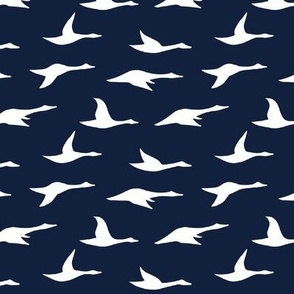 white swans in flight on navy blue