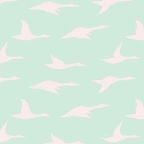 Flying swan silhouette in pale pink on mint green