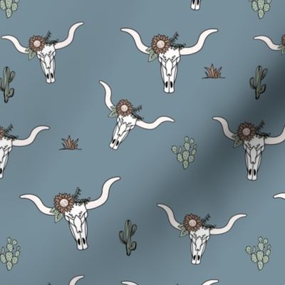 Ranch life with longhorn cows skull flowers and cacti western desert theme on moody blue