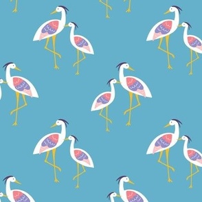 Colorful Standing shoreline Herons in white blue and coral red on baby blue