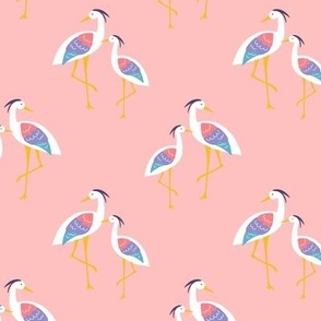 Colorful Standing shoreline Herons in white blue and coral red on blush pink