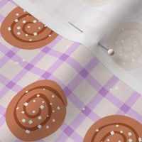 Snack time - cinnamon bun Swedish bakery picnic lunch with sugar sprinkles on plaid lilac purple